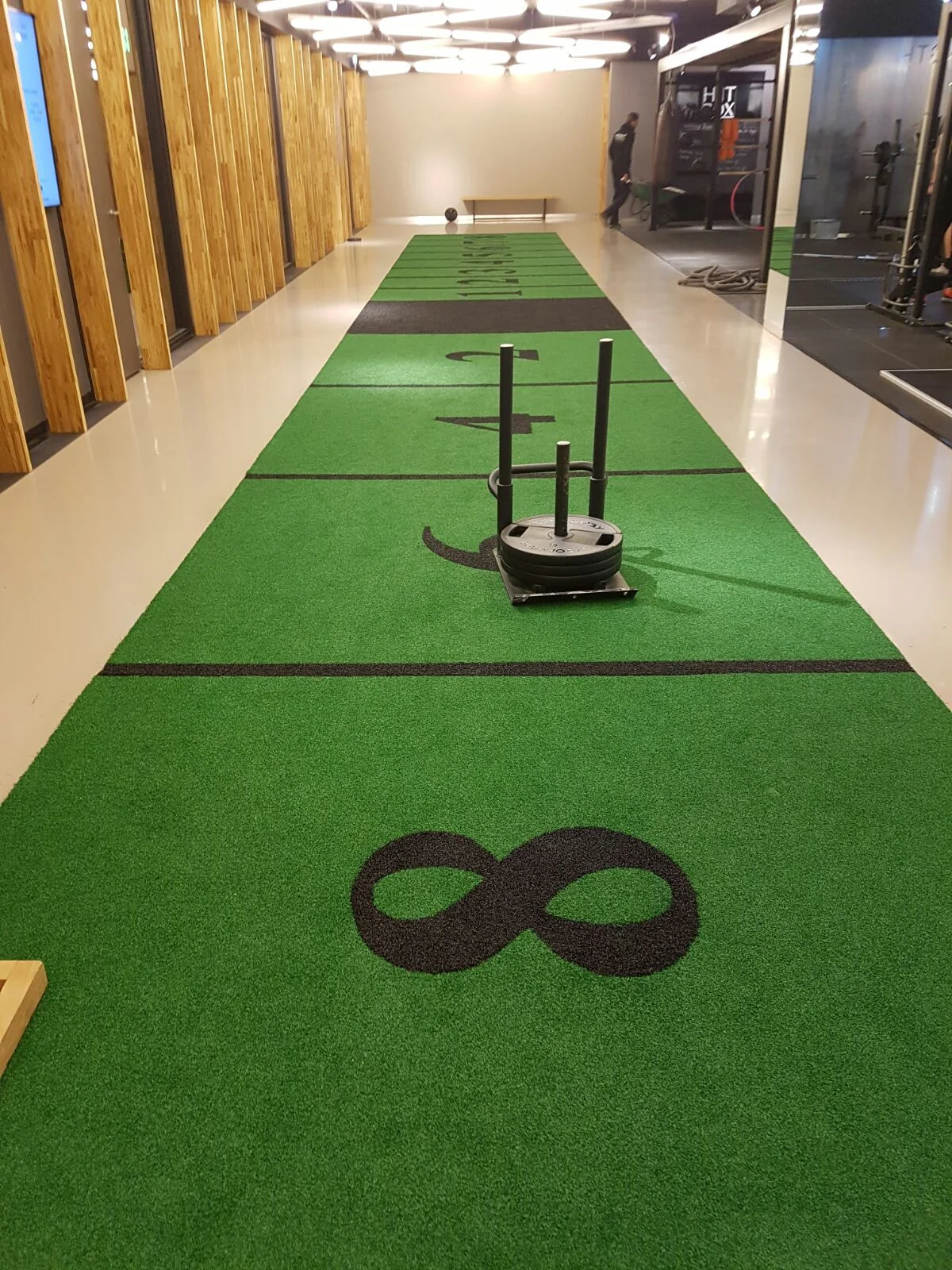 Sledbaan met kunstgras en een slee voor functionele training in een sportschool